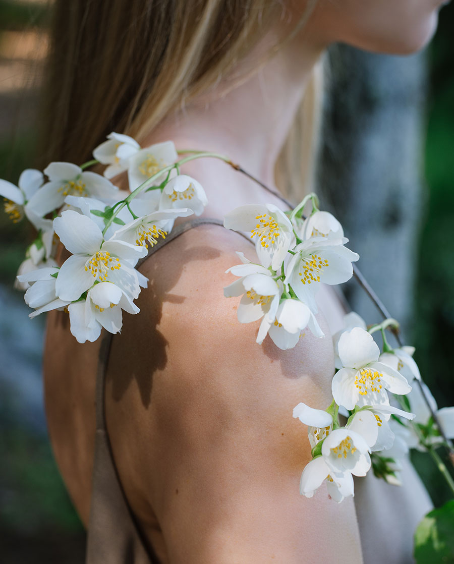 Jasmine blossoms resting on a woman's shoulder